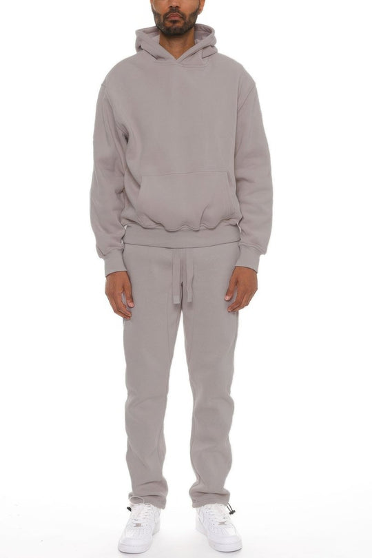 Person wearing a gray tracksuit on a white background