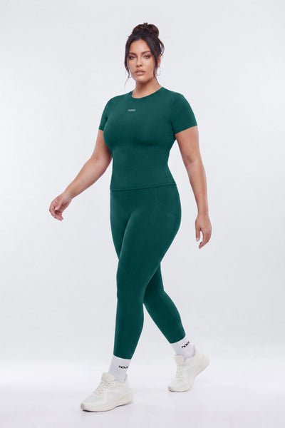 Woman wearing a green athletic outfit on a white background