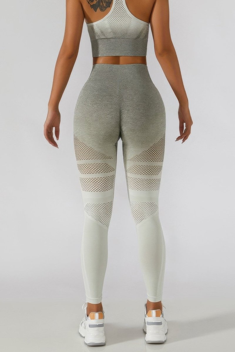 A model shown from the back wearing a matching gray and off-white activewear set, featuring high-waisted leggings with mesh side panels and a matching sports bra, on a light gray studio background.