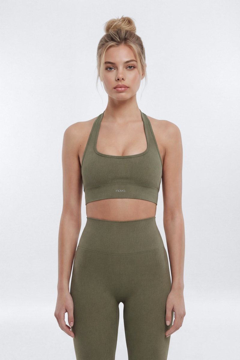 Woman wearing a green sports bra and leggings set on a white background