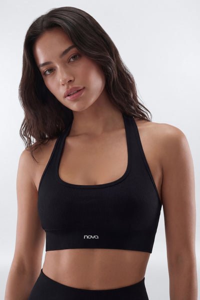 Woman wearing a black sports bra with 'nova' branding on a white background