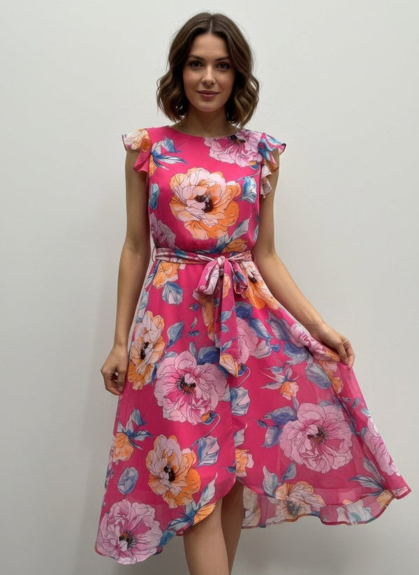 Woman wearing a pink floral dress against a plain background