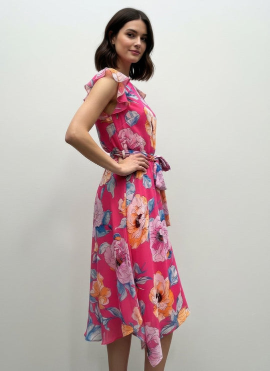 Woman wearing a pink floral dress against a plain background