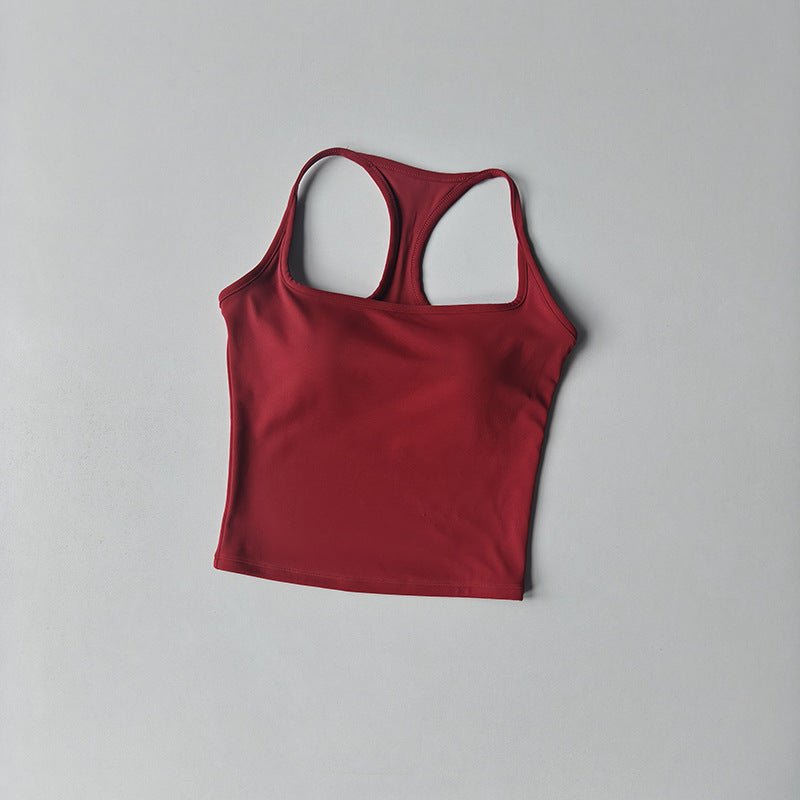 A red racerback tank top with a scoop neckline, laid flat on a light gray background.