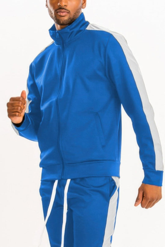 Man wearing a blue tracksuit with white stripes on a white background