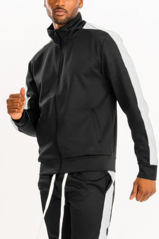 Man wearing a black tracksuit with white stripes on a white background