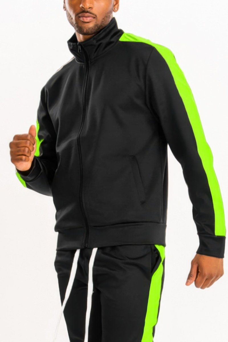 Man wearing a black tracksuit with green accents on a white background