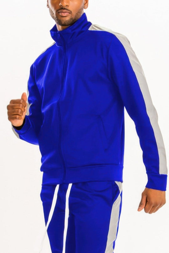 Man wearing a blue tracksuit with white stripes on a white background