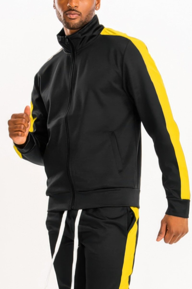 Man wearing a black and yellow tracksuit on a white background