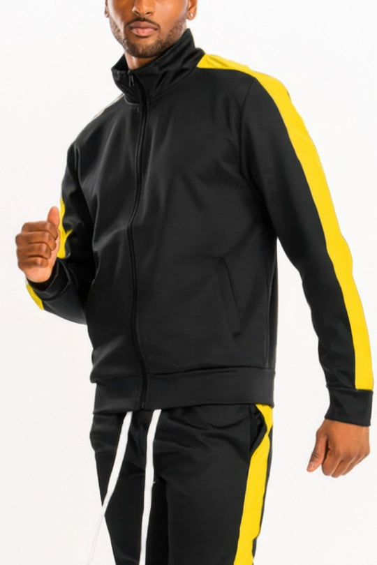 Man wearing a black and yellow tracksuit on a white background