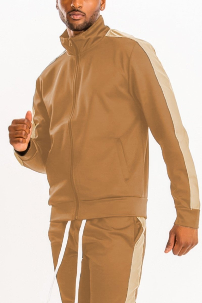 Man wearing a beige tracksuit with white stripes on a white background