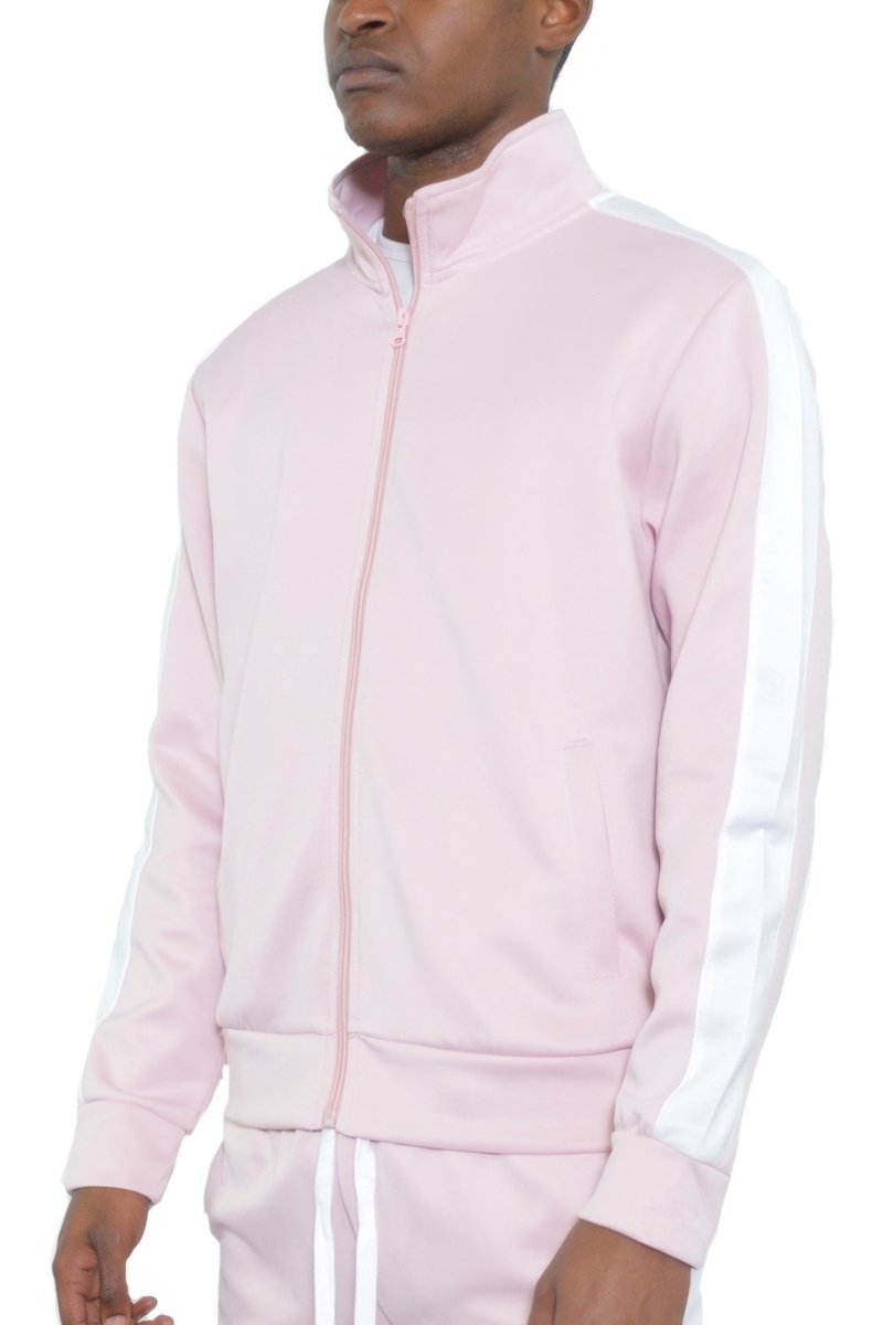 Man wearing a light pink tracksuit with white stripes on a white background