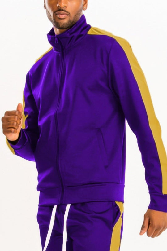 Person wearing a purple tracksuit with gold accents on a white background