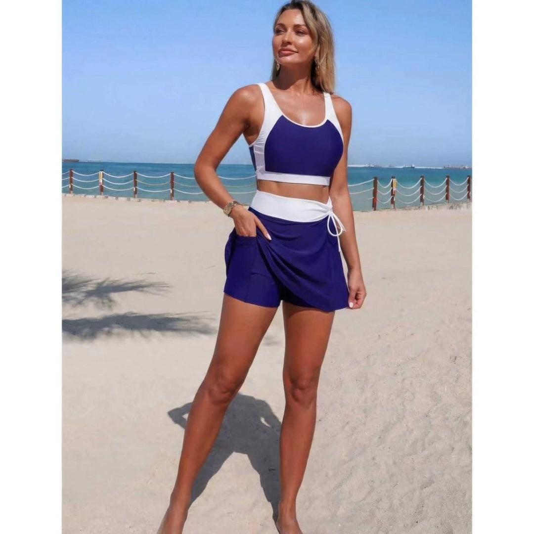 Woman in a blue and white sports outfit standing on a beach.