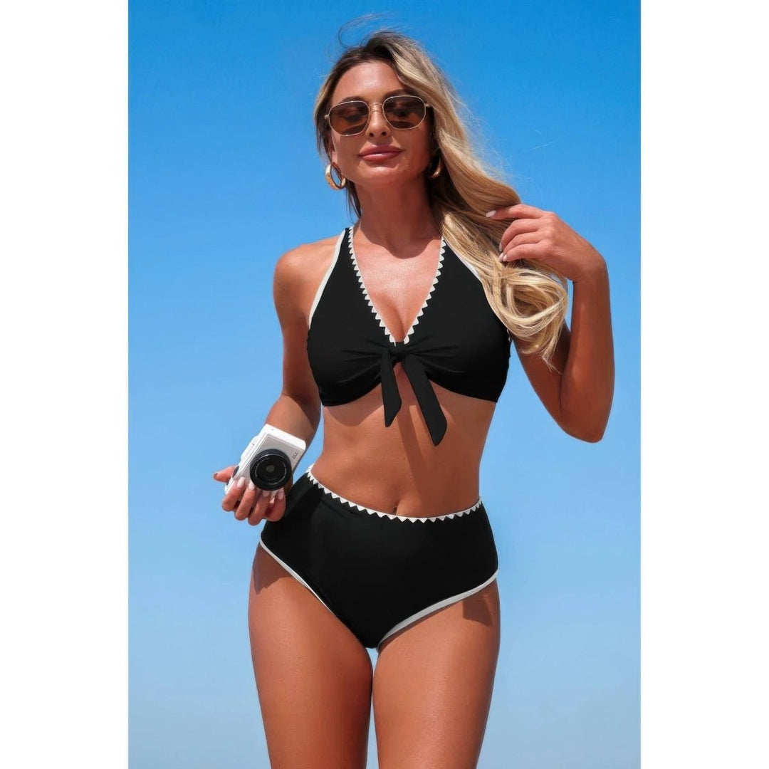 Woman wearing a black bikini with white trim against a blue sky.