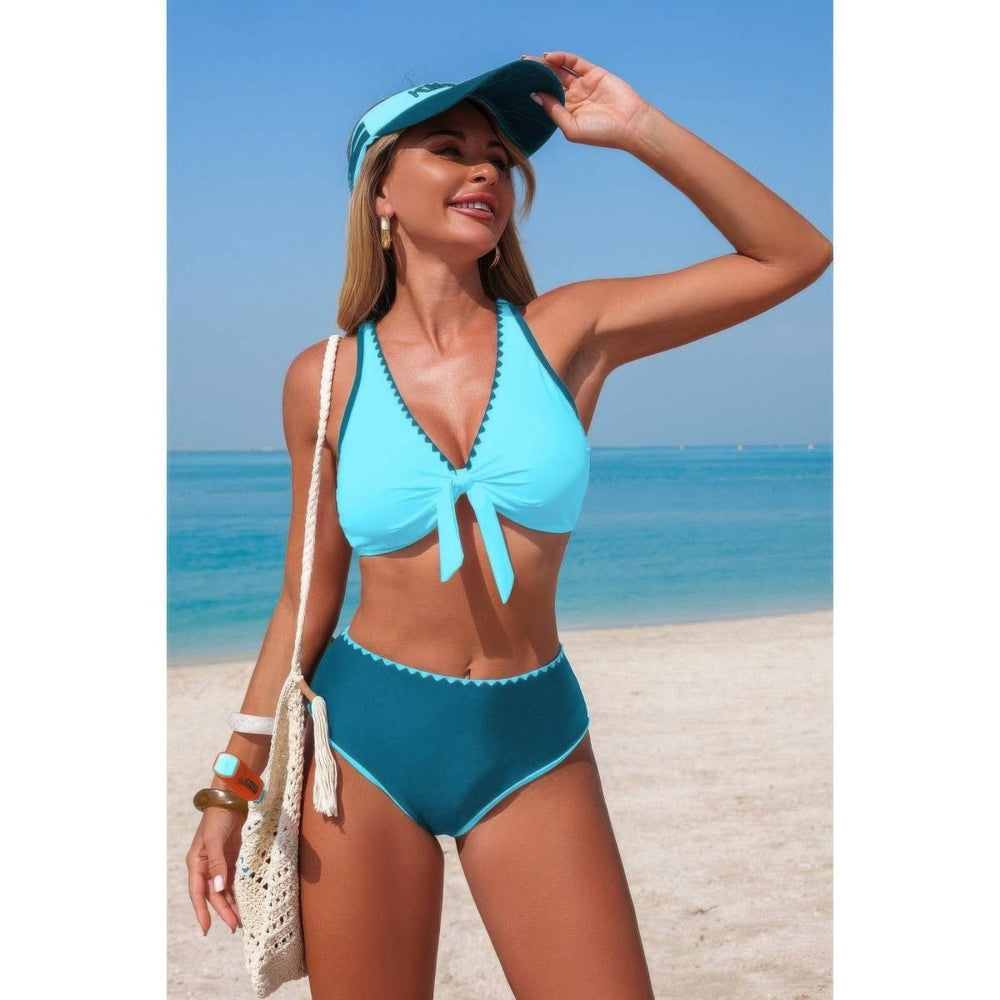 Woman in a blue bikini and visor standing on a beach.