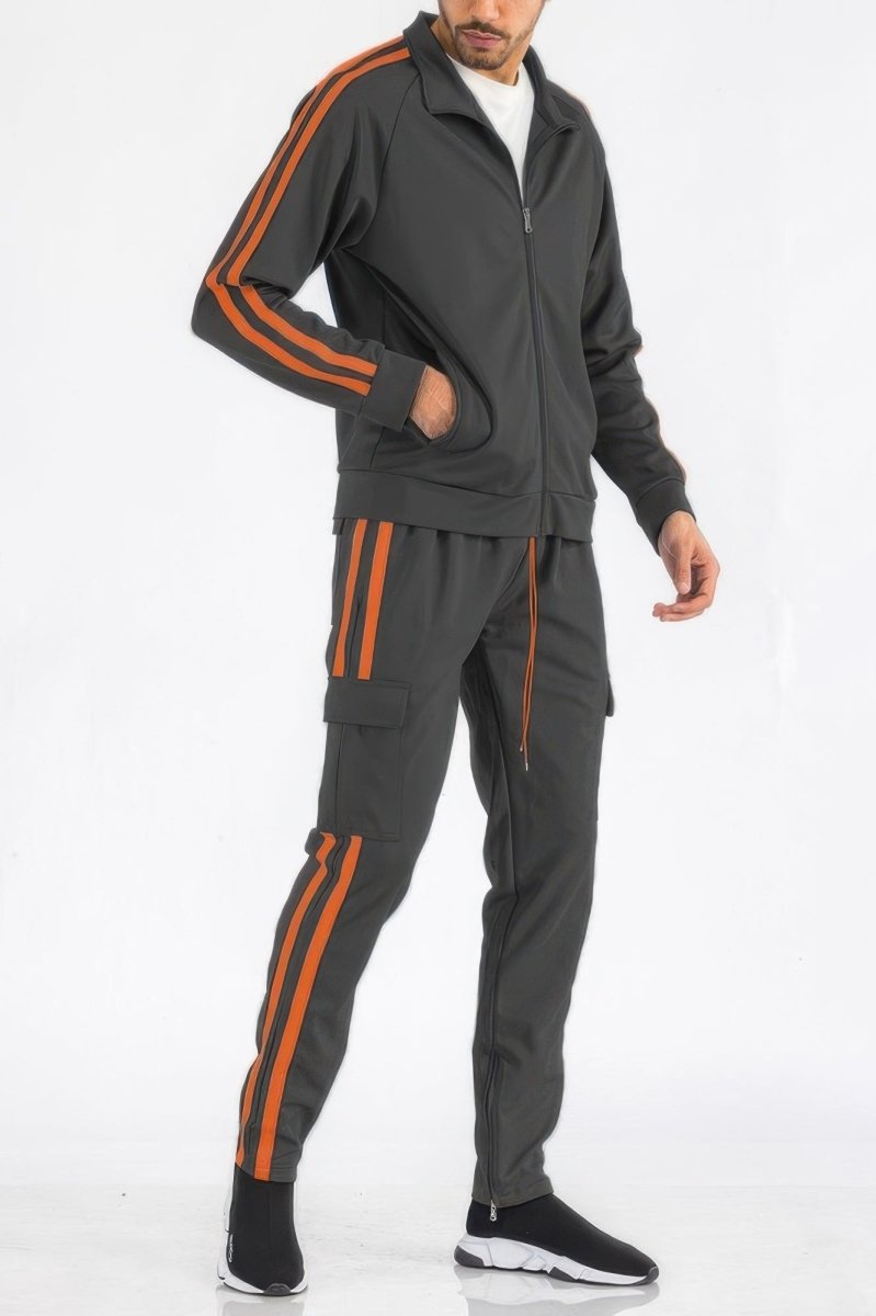 Man wearing a gray tracksuit with orange stripes on a white background