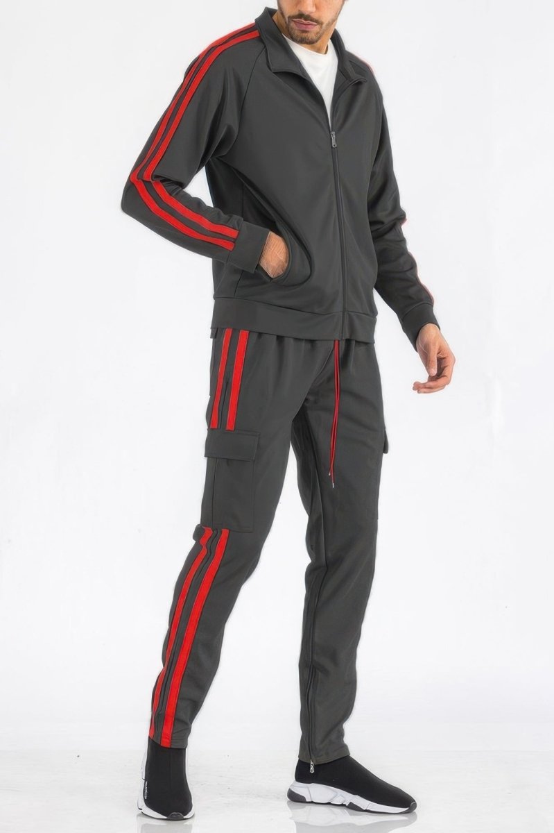 Man wearing a gray tracksuit with red stripes on a white background