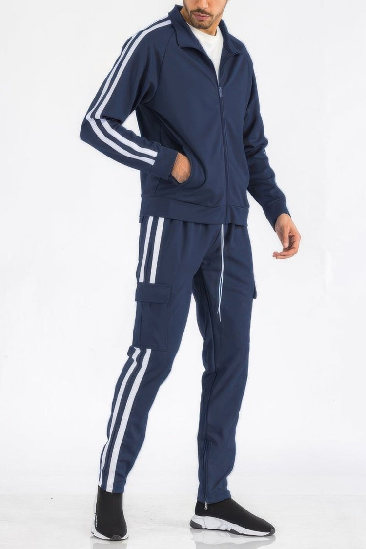 Person wearing a navy tracksuit with white stripes on a white background