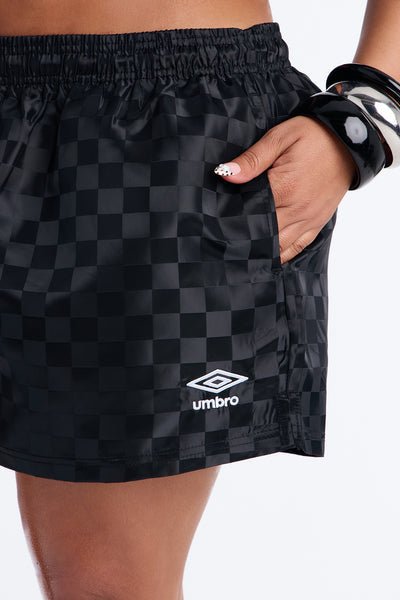Black checkered shorts with Umbro logo on a white background