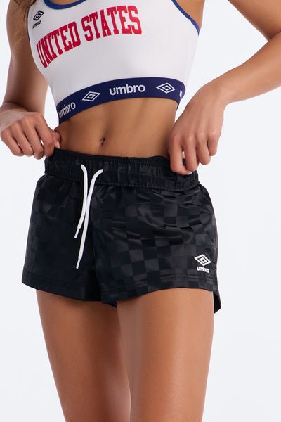 Person wearing a white sports bra with 'United States' text and black checkered shorts, featuring Umbro branding.